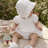 Baby girl in a white Peruvian Pima cotton dress set with crochet Peter Pan collar on a picnic blanket.